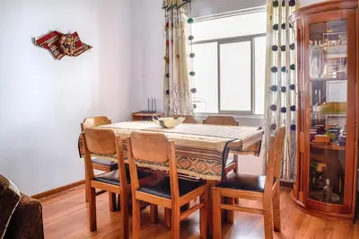 a dining room with a table and chairs and a window at Piso de Kireyna in Cusco