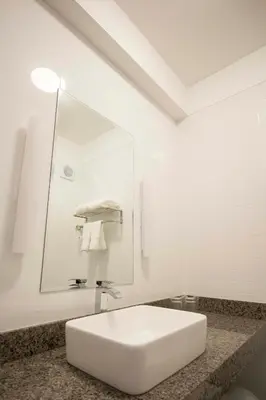 a white bathroom with a sink and a mirror at Tierra Viva Miraflores Centro in Lima