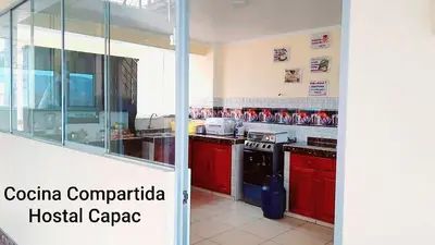 a kitchen with red cabinets and a black stove at Hostal Capac in Ayacucho