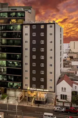 a large apartment building in a city at sunset at Arawi Miraflores Express in Lima
