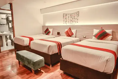 a hotel room with three beds in a room at Casa Matara Boutique in Cusco