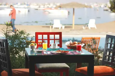 a table with a plate of food on a table with chairs at San Agustin Paracas in Paracas