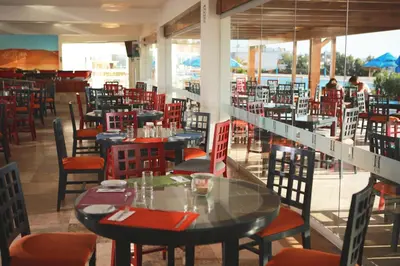 a restaurant with tables and chairs in a room at San Agustin Paracas in Paracas