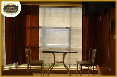 a table and two chairs in front of a window at Dubai Palace in Lima
