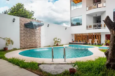 a swimming pool in front of a building at Refugio Hotel in San Ramón