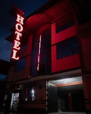 a building with a red neon sign on it at Refugio Hotel in San Ramón