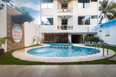 a swimming pool in front of a building at Refugio Hotel in San Ramón