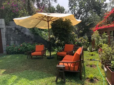 a group of chairs and an umbrella in a yard at Casa Campo Machu Picchu - Club Los Girasoles, Chaclacayo in Chaclacayo