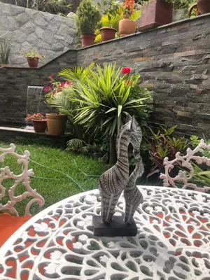 a statue of two cats on a table in a garden at Casa Campo Machu Picchu - Club Los Girasoles, Chaclacayo in Chaclacayo