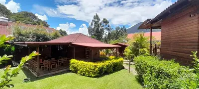 a garden with a building with a grass yard at Chontaqui Eco-Lodge in Oxapampa