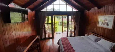 a bedroom with a bed and a large window at Chontaqui Eco-Lodge in Oxapampa