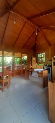 a large room with wooden ceilings and tables and benches at Chontaqui Eco-Lodge in Oxapampa