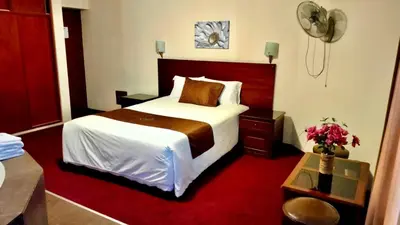 a hotel room with a bed and a red carpet at Hotel Ferrua in Lima