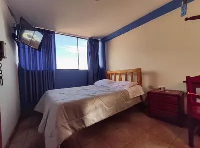 a bedroom with a bed and a large window at Hospedaje Manchego's in Huancayo