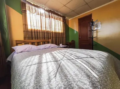 a bedroom with a large bed with a window at Hospedaje Manchego's in Huancayo
