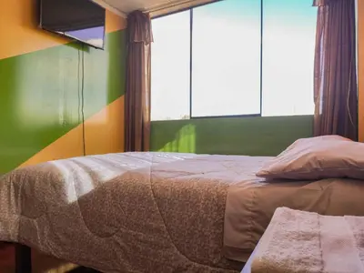 a small bedroom with a bed and a window at Hospedaje Manchego's in Huancayo
