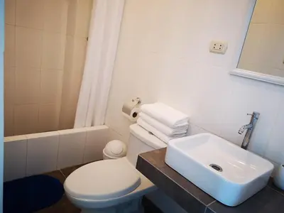 a bathroom with a white toilet and a sink at Coco Lodge Paracas in Paracas