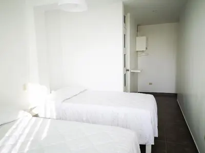 two beds sitting next to each other in a room at Coco Lodge Paracas in Paracas