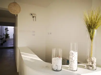 two glass vases sitting on a table with flowers at Coco Lodge Paracas in Paracas