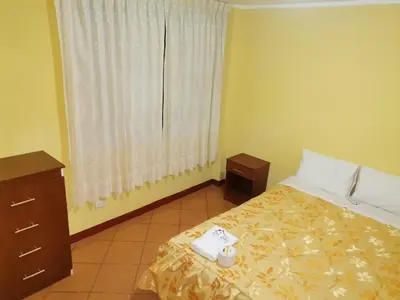 a hotel room with a bed and a window at Hospedaje Las Lilas in Huancayo