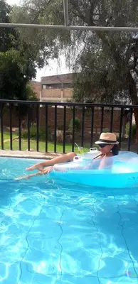 a woman in a hat in a swimming pool at Casa Montemira in Ica