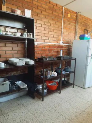 a kitchen with shelves with dishes and a refrigerator at Casa Montemira in Ica