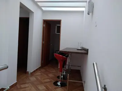 a room with a table and a red stool at Departamento en el centro de San Borja (Rubens) in Lima