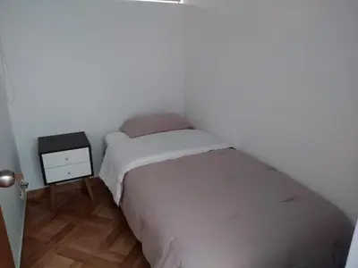 a small bedroom with a bed and a night stand at Departamento en el centro de San Borja (Rubens) in Lima
