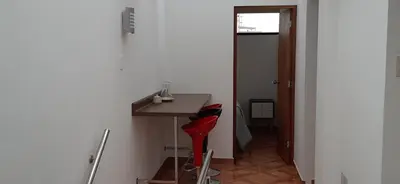 a bathroom with a red stool next to a sink at Departamento en el centro de San Borja (Rubens) in Lima