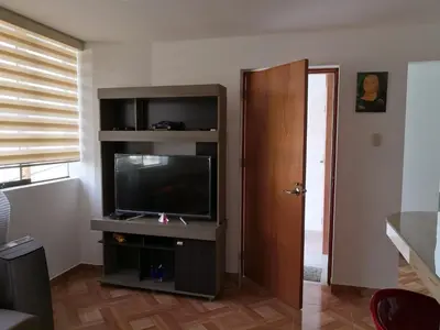 a living room with a flat screen tv on a entertainment center at Departamento en el centro de San Borja (Rubens) in Lima