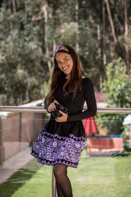 a woman in a dress holding a camera at Bull House in Urubamba