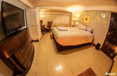 a hotel room with a bed and a flat screen tv at Bull House in Urubamba