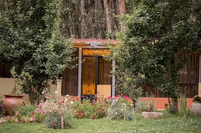 a house with a yellow door and some flowers at Bull House in Urubamba