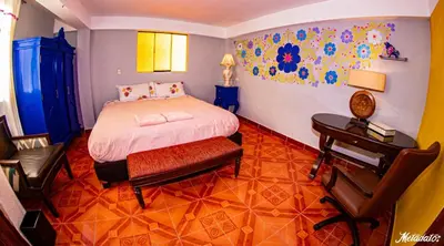 a bedroom with a bed and a table and a desk at Bull House in Urubamba