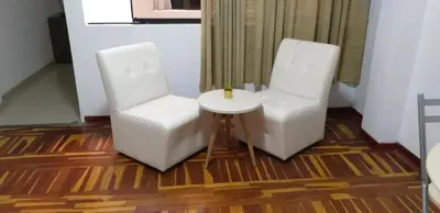 two white chairs and a table in a room at Peruvian Family Hostal Miraflores in Lima