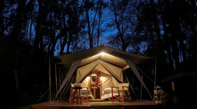 a tent with chairs and lights in the night at Glamping Chaska Ocupi in Urubamba