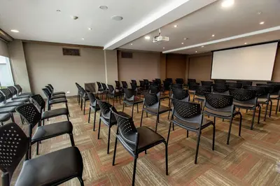a conference room with chairs and a white screen at Hampton By Hilton Lima San Isidro in Lima