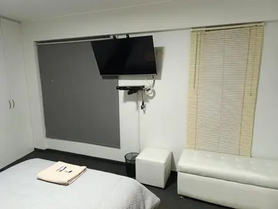 a room with a bed and a couch and a flat screen tv at MIRAFLORES APART-10Beds-11Persons-Pool-Grill-Garage-Near Kennedy Park in Lima