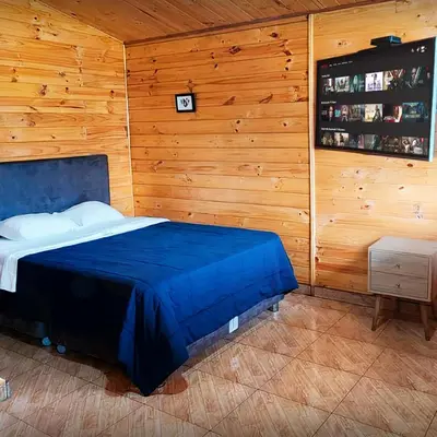 a bedroom with a blue bed in a wooden wall at Apart Hotel El Paraíso de Barranca in Barranca