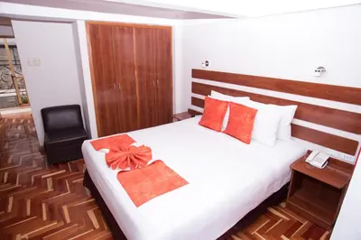 a hotel room with a bed with a bow on it at Hotel Arcangel in Cusco