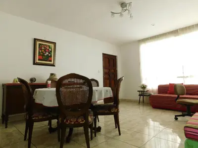 a dining room with a table and chairs and a couch at Teté in Lima