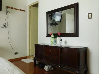 a bedroom with a dresser and a mirror on the wall at Teté in Lima