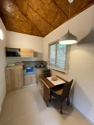a kitchen with a wooden table and a dining room at Mercedes Lodge in San Ramón