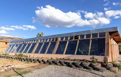 a building with a bunch of pots in front of it at Casa 100% ecológica con vista a los glaciares andinos in Maras