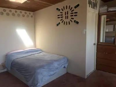 a bedroom with a bed and a clock on the wall at Casa 100% ecológica con vista a los glaciares andinos in Maras