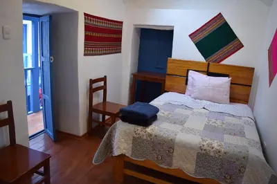 a bedroom with a bed with a quilt on it at Carlos Guest House 3 Cusco in Cusco