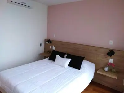 a bedroom with a bed with white sheets and black pillows at MLA apartments - Buenos Aires in Lima