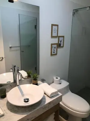 a bathroom with a sink and a toilet and a mirror at MLA apartments - Buenos Aires in Lima