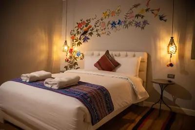 a bedroom with a bed with towels on it at Home Garden Hotel in Cusco
