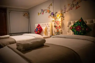 a bedroom with three beds with a stuffed animal on the bed at Home Garden Hotel in Cusco